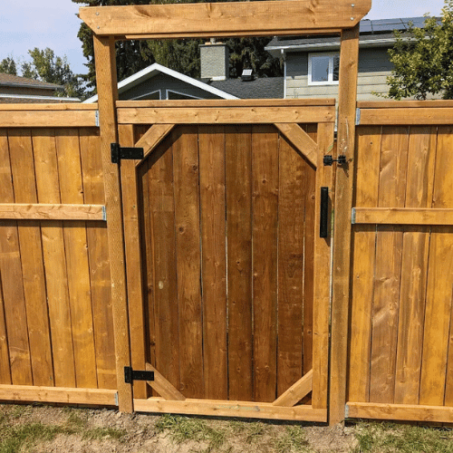 Beautiful backyard fence and deck completed by All The Moore Landscaping